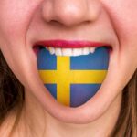 舌にスウェーデン国旗をつけた女性 - 外国語を学ぶ