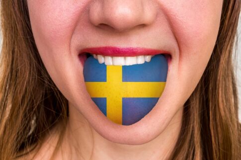 舌にスウェーデン国旗をつけた女性 - 外国語を学ぶ